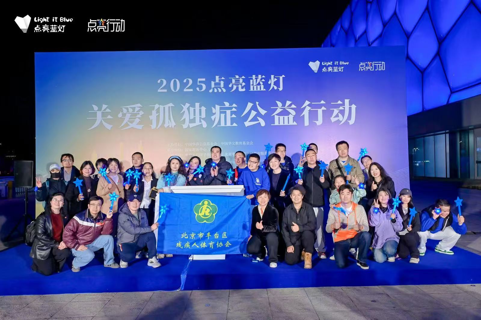 A group photograph at the 2025 Light It Up Blue autism awareness event at the Water Cube
