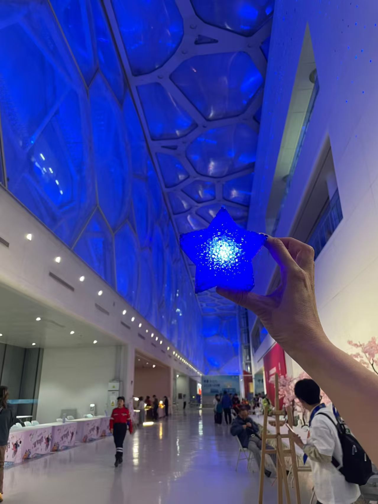 A blue star light inside the illuminated Water Cube